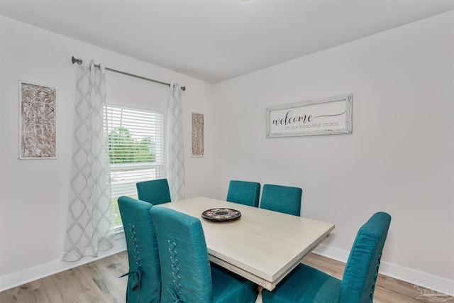 dining space featuring baseboards and wood finished floors