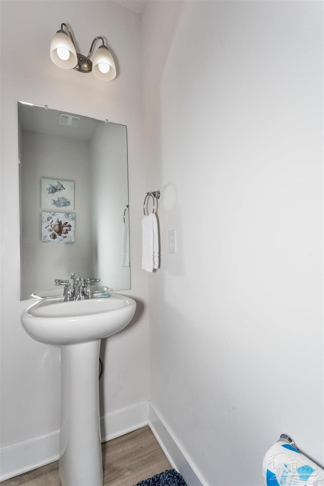 bathroom with wood finished floors and baseboards