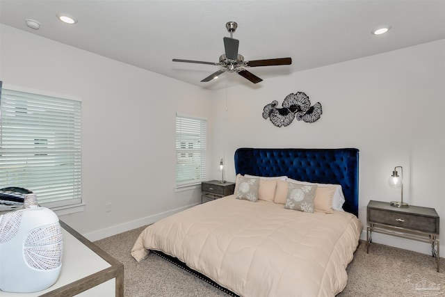 bedroom with light carpet, multiple windows, baseboards, and recessed lighting