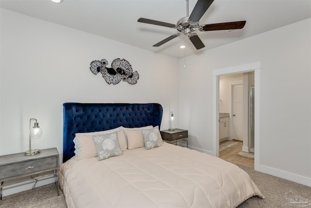 bedroom with recessed lighting, light carpet, connected bathroom, and baseboards