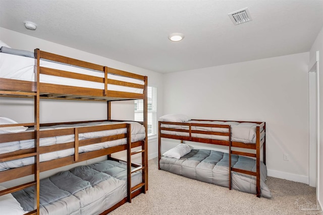 carpeted bedroom with visible vents and baseboards