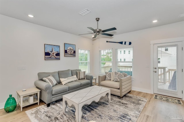 living area with recessed lighting, light wood-type flooring, visible vents, and baseboards