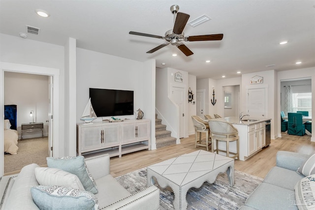 living area featuring stairway, light wood-style flooring, visible vents, and recessed lighting