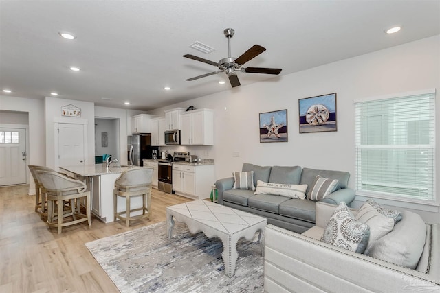 living area featuring recessed lighting, visible vents, and light wood-style floors