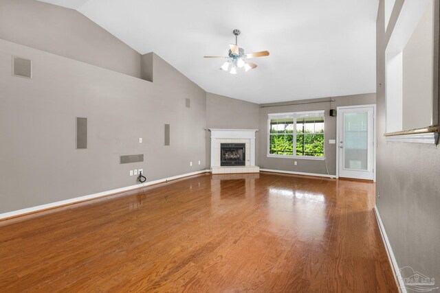 unfurnished living room with wood finished floors, a fireplace, baseboards, and a ceiling fan