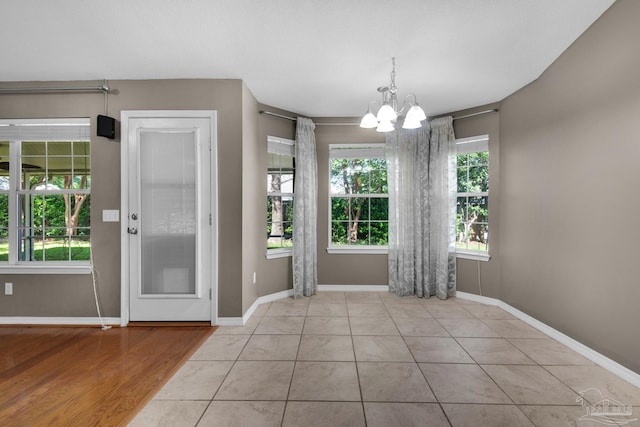 interior space featuring an inviting chandelier, baseboards, and a wealth of natural light