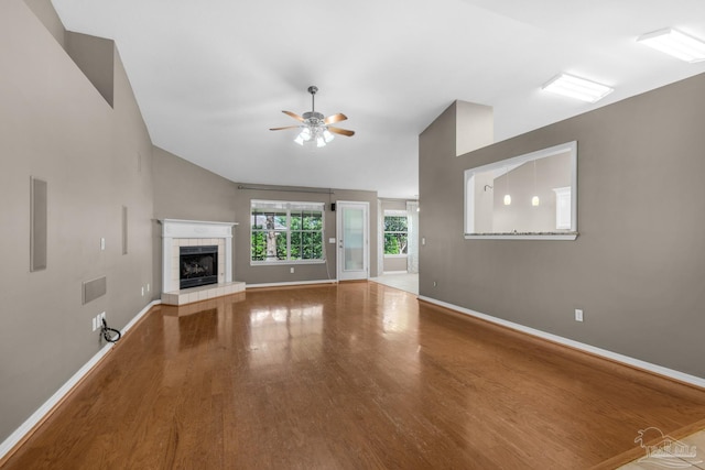 unfurnished living room with wood finished floors, baseboards, vaulted ceiling, and ceiling fan