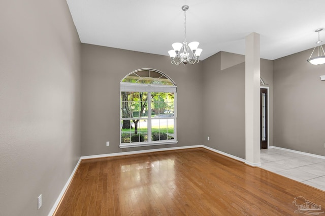 interior space with wood finished floors, baseboards, and a notable chandelier