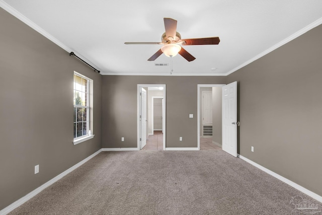 unfurnished bedroom with baseboards, ornamental molding, visible vents, ceiling fan, and light colored carpet