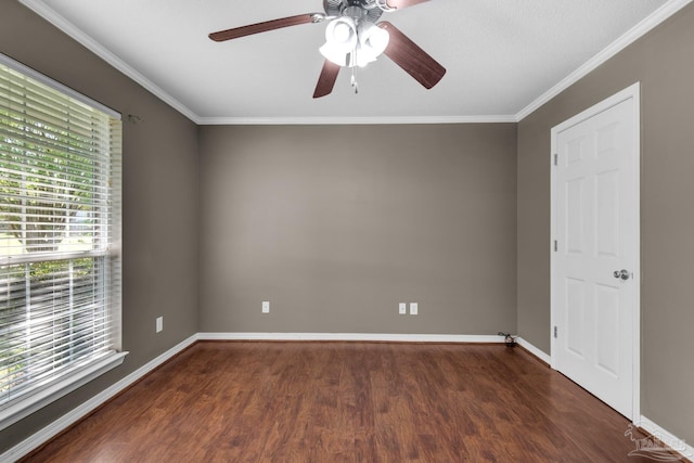 spare room with wood finished floors, ornamental molding, baseboards, and a ceiling fan