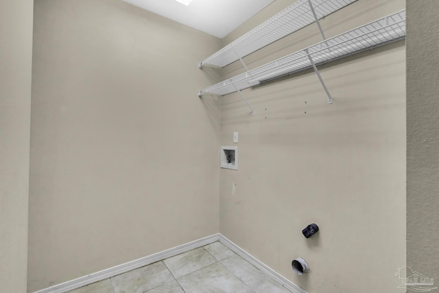 clothes washing area featuring laundry area, light tile patterned floors, baseboards, and hookup for a washing machine