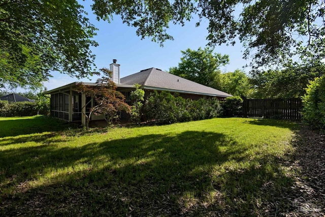 view of yard with fence and a sunroom