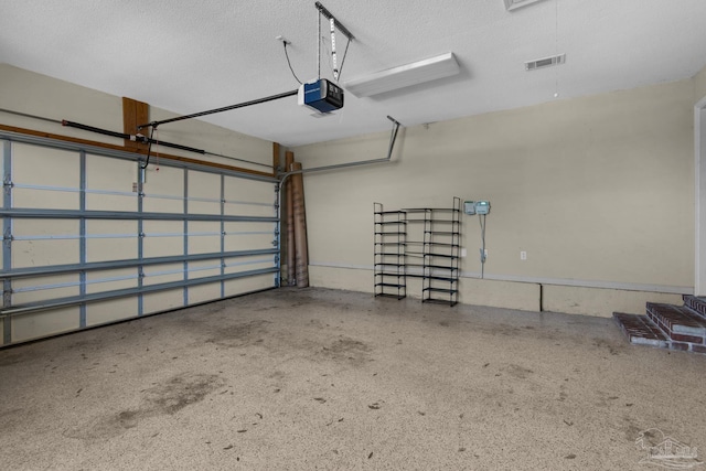 garage with a garage door opener and visible vents