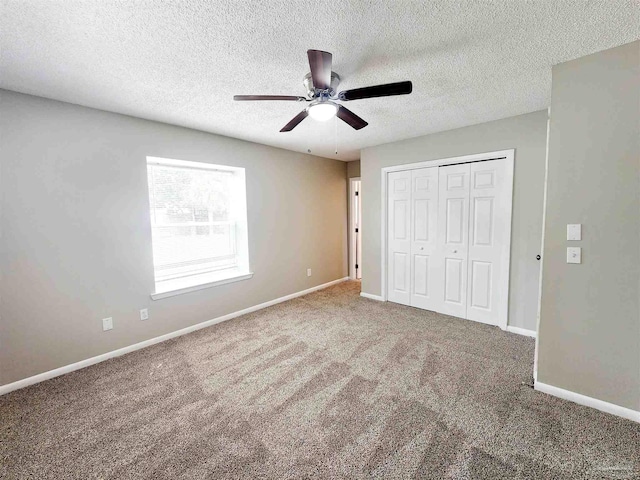 unfurnished bedroom featuring a textured ceiling, carpet flooring, a closet, and ceiling fan