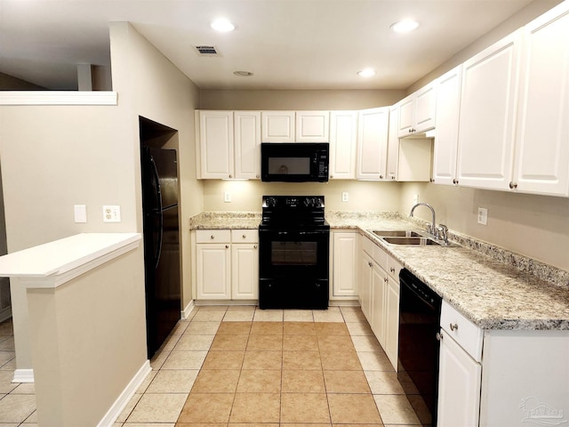 kitchen with light tile patterned flooring, white cabinets, black appliances, and sink