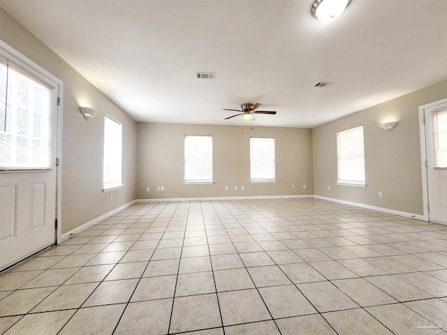 spare room with ceiling fan and light tile patterned floors