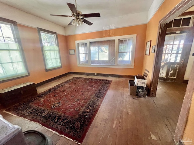 sitting room with ceiling fan, wood-type flooring, and a wealth of natural light