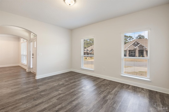 unfurnished room with dark hardwood / wood-style flooring