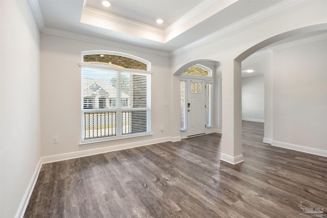 entrance foyer with dark hardwood / wood-style floors, ornamental molding, and a raised ceiling