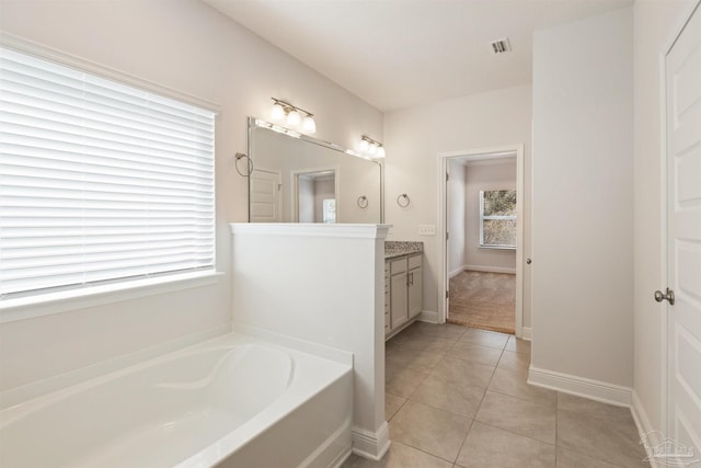 bathroom with tile patterned flooring, vanity, and a washtub