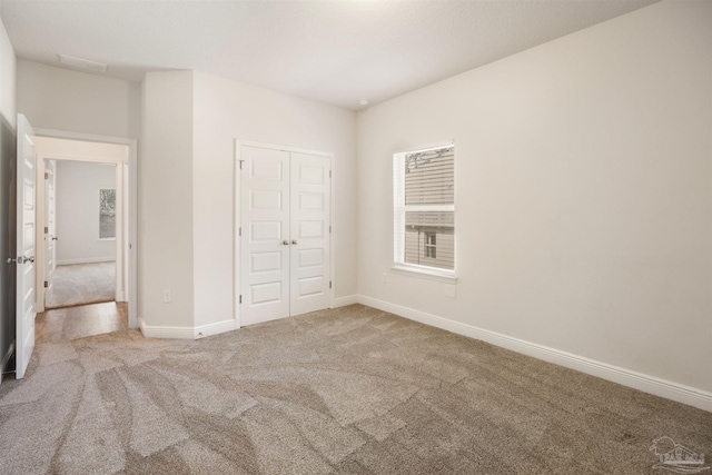 unfurnished bedroom featuring carpet flooring and a closet