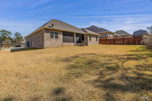 back of property featuring a lawn and a sunroom