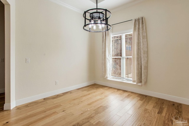 unfurnished dining area featuring a notable chandelier, crown molding, light hardwood / wood-style floors, and plenty of natural light