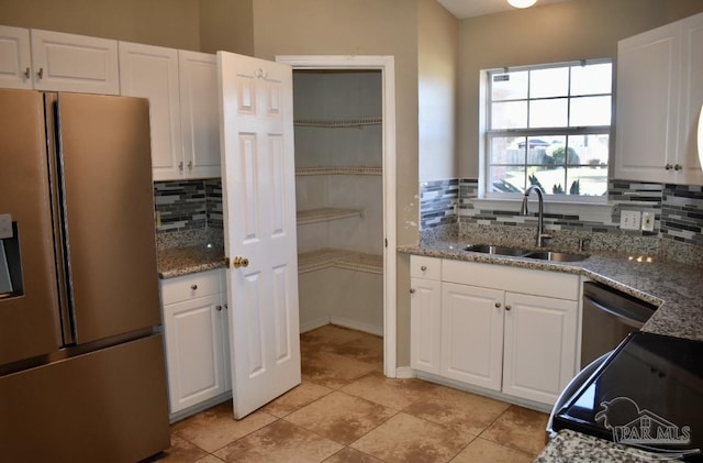 kitchen featuring stone counters, white cabinetry, sink, refrigerator with ice dispenser, and backsplash