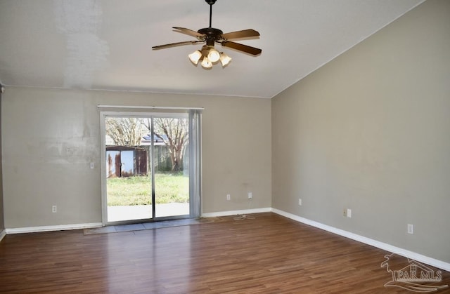 spare room with dark hardwood / wood-style flooring, vaulted ceiling, and ceiling fan