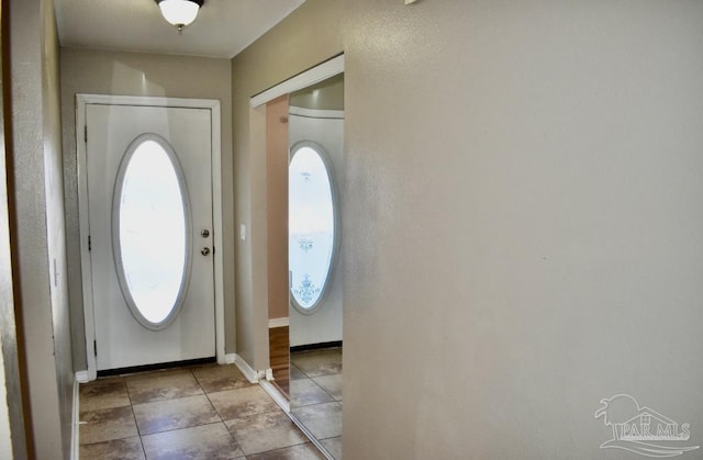 entrance foyer featuring light tile patterned floors and a healthy amount of sunlight