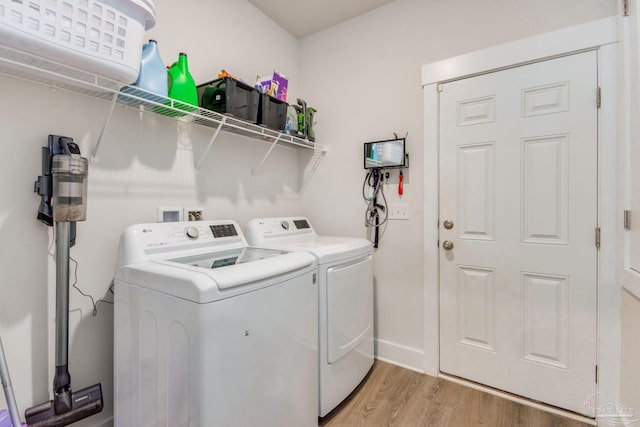 washroom with separate washer and dryer and light hardwood / wood-style flooring