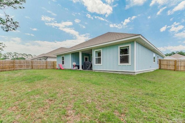 rear view of property featuring a lawn