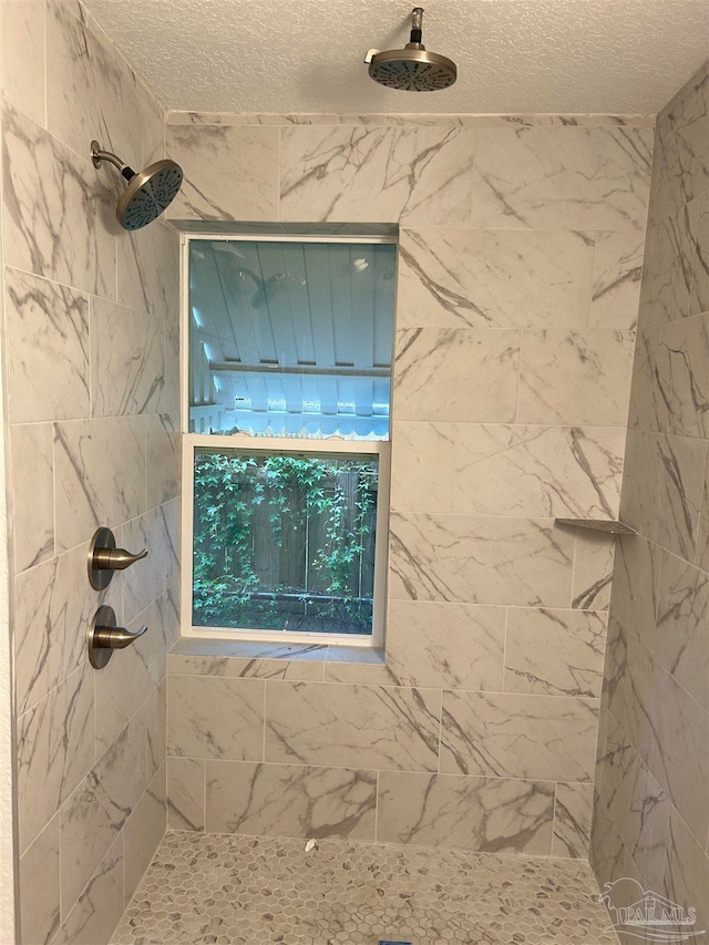 details featuring a textured ceiling and a tile shower