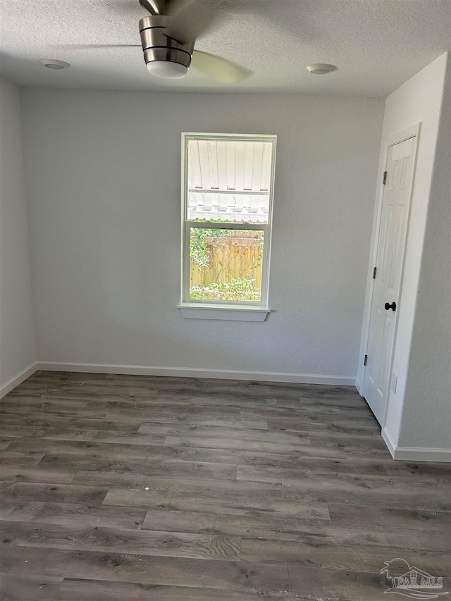 spare room featuring a textured ceiling, ceiling fan, and dark wood-type flooring