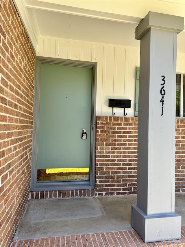 entrance to property with brick siding and board and batten siding
