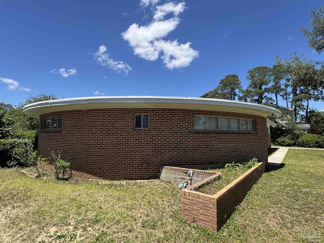 rear view of property with brick siding and a yard