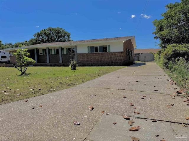 ranch-style house with a gate, a front yard, driveway, and brick siding