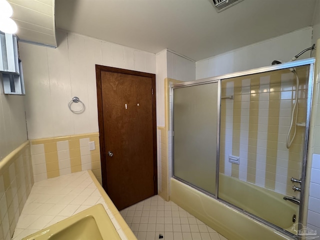 full bathroom featuring tile patterned flooring, a sink, combined bath / shower with glass door, and visible vents