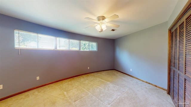 unfurnished bedroom with ceiling fan, light colored carpet, baseboards, visible vents, and a closet