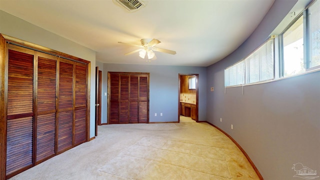 unfurnished bedroom featuring visible vents, baseboards, ceiling fan, and light colored carpet
