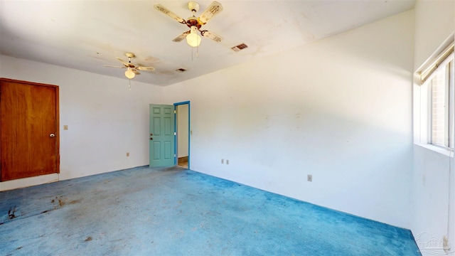 spare room with carpet flooring, ceiling fan, and visible vents