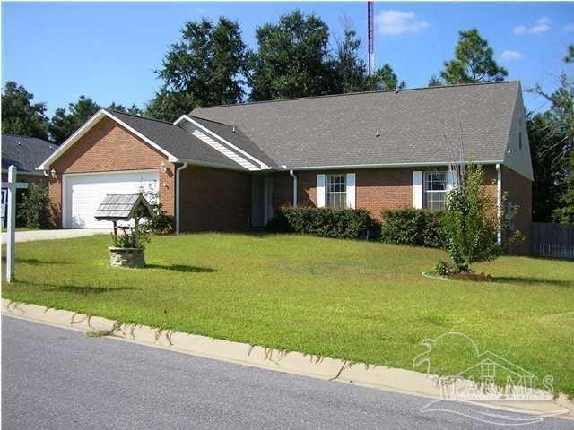 ranch-style home featuring an attached garage, brick siding, and a front yard