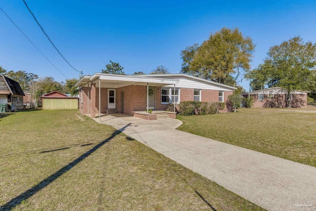 view of front of home featuring a front yard, an attached carport, concrete driveway, and brick siding