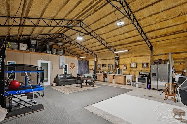 7664 Buffalo Ridge Rd, Pace, FL 32571 - garage featuring stainless steel fridge and wood walls