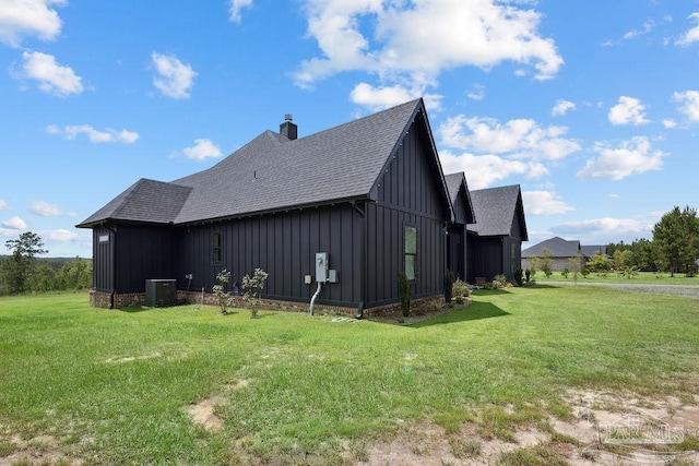 7664 Buffalo Ridge Rd, Pace, FL 32571 - view of home's exterior featuring board and batten siding, roof with shingles, a yard, and a chimney