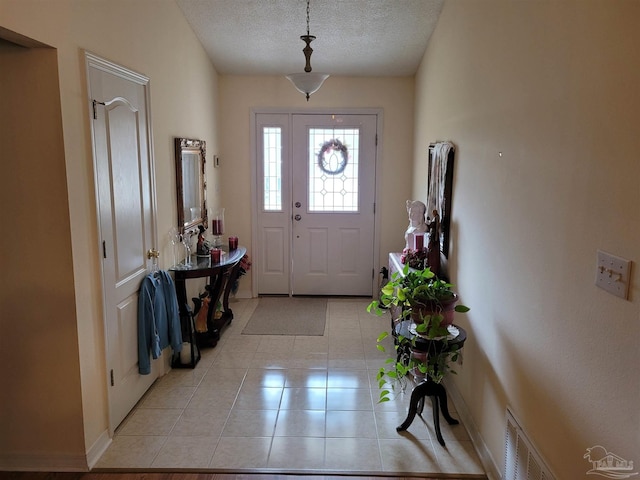 entrance foyer with visible vents, a textured ceiling, and light tile patterned flooring