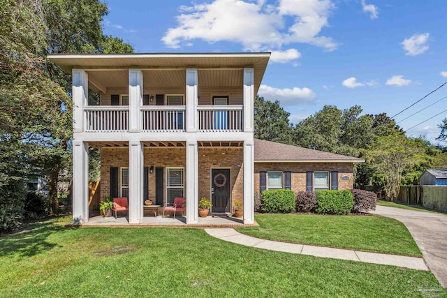 view of front facade featuring a balcony, a front lawn, and a patio