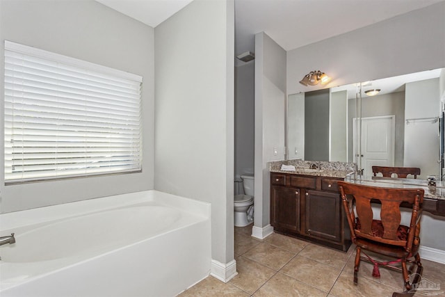 bathroom with vanity, tile patterned flooring, toilet, and a bath