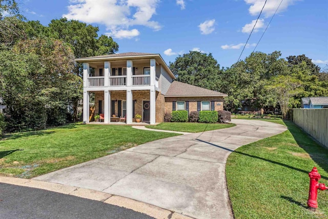 view of front of property with a balcony and a front lawn