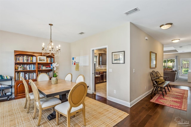 dining space featuring a notable chandelier and dark hardwood / wood-style floors